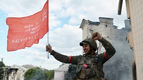 A fighter of the 6th Platov Cossack Regiment of the LPR installs the banner of the collapsed Union of Soviet Socialist Republics on the city administration building in Lisichansk, the Luhansk People's Republic. © Sputnik / Viktor Antonyuk