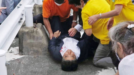 Japan’s former Prime Minister Shinzo Abe, center, falls on the ground in Nara, western Japan Friday, July 8, 2022. © AP / Kyodo News