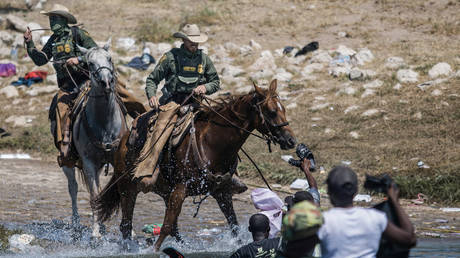 FILE PHOTO: Mounted US Border Patrol agents attempt to contain migrants as they cross the Rio Grande from Ciudad Acuña, Mexico, into Del Rio, Texas, Sept. 19, 2021