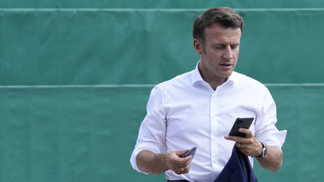PHOTO DE FICHIER.  Le président français Emmanuel Macron regarde son téléphone.  26 juin 2022.