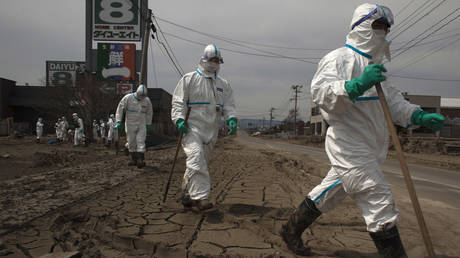 FILE PHOTO. Japanese Police wearing protective suits search for tsunami victims within the exclusion zone, about 12 miles (20 kilometers) away from Fukushima Nuclear Power Plant on April 7, 2011 in Minamisoma, Fukushima Prefecture, Japan.