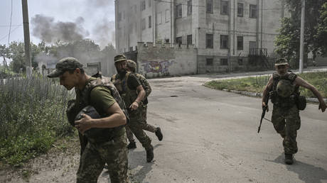 Ukrainian servicemen run for cover amid a Russian shelling. © AFP / Aris Messinis