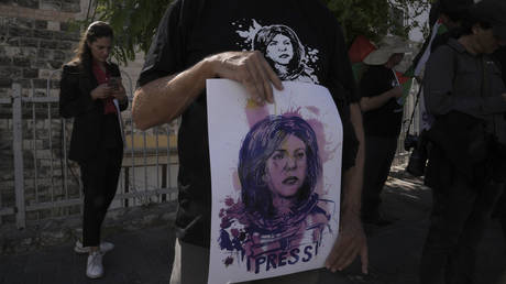 Protesters hold posters for slain Palestinian-American journalist Shireen Abu Akleh near the Augusta Victoria Hospital in east Jerusalem ahead of a visit by US President Joe Biden, July 15, 2022.