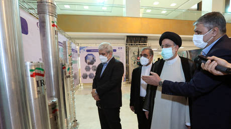 Iran's President Ebrahim Raisi (2-R) accompanied by the Atomic Energy Organization of Iran (AEOI) chief Mohammad Eslami (R) attending an event in Tehran. ©Iranian Presidency via AFP