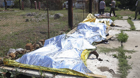 EDS NOTE: GRAPHIC CONTENT - Investigators examine bodies of Ukrainian military prisoners at a prison in Olenivka, in an area controlled by Russian-backed separatist forces, eastern Ukraine, Friday, July 29, 2022.