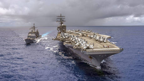 FILE PHOTO: American aircraft carrier USS Ronald Reagan and guided-missile cruiser USS Antietam perform refueling at sea. © AFP / US Navy