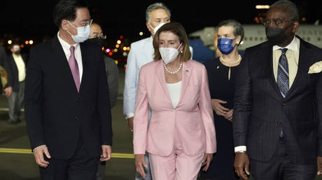 U.S. House Speaker Nancy Pelosi, center, walks with Taiwan's Foreign Minister Joseph Wu, left, as she arrives in Taipei, Taiwan, Tuesday, Aug. 2, 2022.