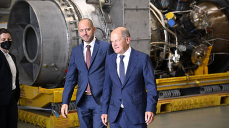 German Chancellor Olaf Scholz (R) and Christian Bruch, President and CEO of Siemens Energy, walk past a turbine of the Nord Stream 1 pipeline during a visit on August 3, 2022 at the plant of Siemens Energy in Muelheim an der Ruhr. © Sascha Schuermann / AFP