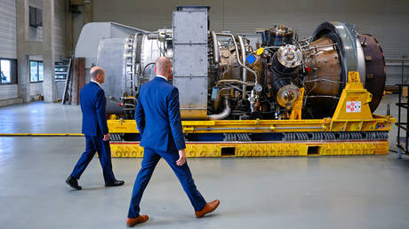 German Chancellor Olaf Scholz (L) and Christian Bruch, President and CEO of Siemens Energy, walk past a turbine of the Nord Stream 1 pipeline during a visit on August 3, 2022 at the plant of Siemens Energy in Muelheim an der Ruhr, western Germany. © SASCHA SCHUERMANN / AFP