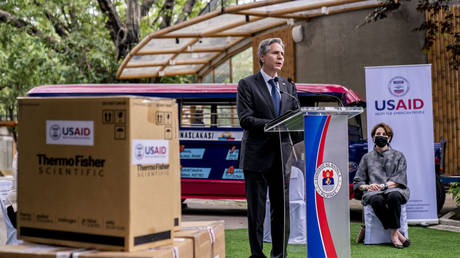 Boxes of medical equipment marked with USAID labels are visible next to Secretary of State Antony Blinken as he speaks outside a COVID-19 vaccination clinic  in Manila, Philippines, August 6, 2022