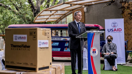 Boxes of medical equipment marked with USAID labels are visible next to Secretary of State Antony Blinken as he speaks outside a COVID-19 vaccination clinic in Manila, Philippines, August 6, 2022