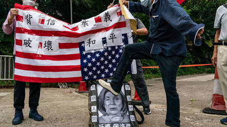 A pro-China supporter steps on a defaced photo of US House of Representatives Speaker Nancy Pelosi during a protest against her visit to Taiwan outside the Consulate General of the United States on August 03, 2022 in Hong Kong, China. © Anthony Kwan / Getty Images