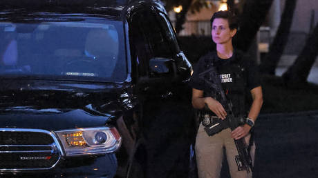 An armed Secret Service agent stands outside an entrance to Mar-a-Lago estate amid an FBI raid. ©AP Photo / Terry Renna