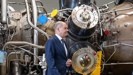 German Chancellor Olaf Scholz stands in front of the turbine serviced in Canada for the Nord Stream 1 gas pipeline on August 3, 2022