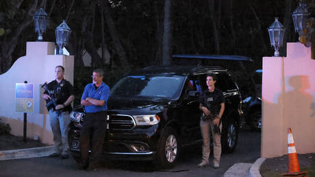 Des agents des services secrets armés se tiennent devant l'entrée du domaine Mar-a-Lago de l'ancien président Donald Trump, le 8 août 2022, à Palm Beach, en Floride.