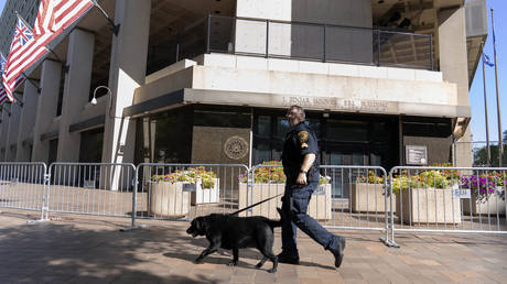 A Federal Bureau of Investigation police officer walks with his working dog outside FBI headquarters in Washington, DC, August 13, 2022 © AP / Jose Luis Magana