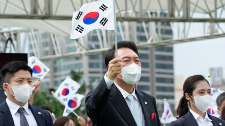 President Yoon Suk-yeol is shown waving a South Korean flag during the country's Liberation Day celebration on Monday.