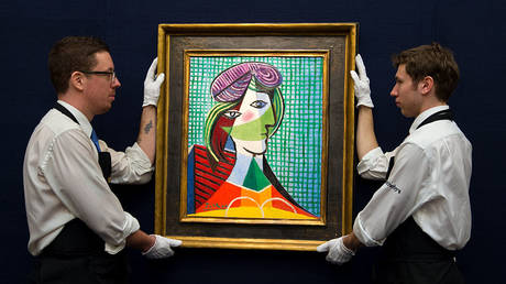FILE PHOTO: Art handlers are shown hanging a Pablo Picasso painting at a February 2016 Sotheby's auction in London.