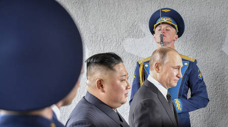 FILE - In this Thursday, April 25, 2019 file photo, President Vladimir Putin and North Korean leader Kim Jong Un, center, walk past honor guard officers during their meeting in Vladivostok, Russia.