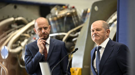 German Chancellor Olaf Scholz stands next to Christian Bruch, President and CEO of Siemens Energy, in front of a turbine of the Nord Stream 1 pipeline, August 3, 2022