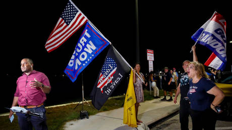 Supporters of Donald Trump are shown near the former president's Palm Beach, Florida, home protesting as a television journalist tries to report on the FBI raid earlier this month.