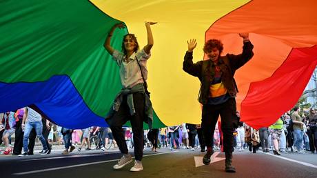 FILE PHOTO: Participants dance under a huge rainbow flag during the Belgrade Pride march. AFP / Anderj Isakovic