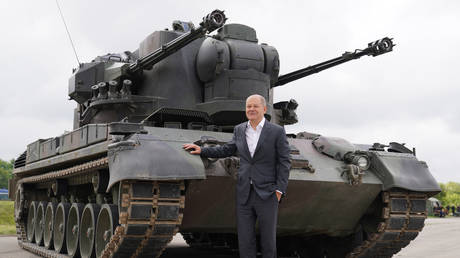 German Chancellor Olaf Scholz poses near a Gepard anti-aircraft gun tank in Schleswig-Holstein, Germany, August 25, 2022. © Marcus Brandt / Picture Alliance / Getty Images