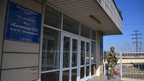 A serviceman of the Russian National Guard stands at the entrance of the administrative building of the Kakhovka Hydroelectric Power Plant, in Kherson region, Ukraine. © Sputnik