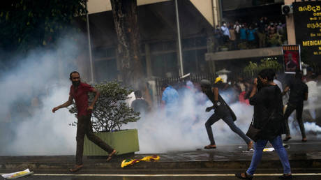 People running from tear gas and water cannons in Colombo, Sri Lanka on August 30, 2022.