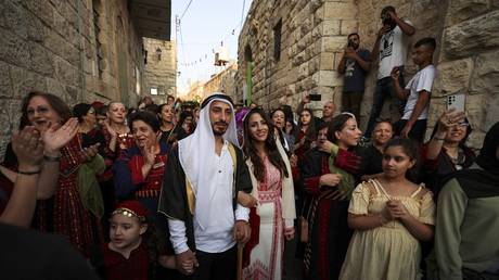 FILE PHOTO: A Palestinian Christian couple dressed in traditional outfits on their wedding day in the town of Birzeit near the West Bank city of Ramallah, August 3, 2022