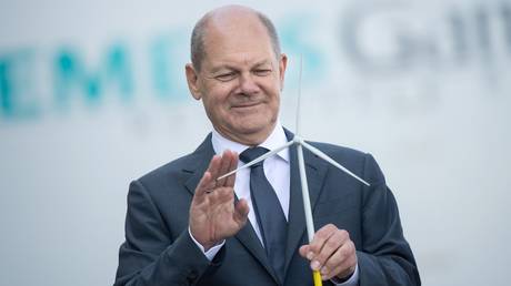 FILE PHOTO. Olaf Scholz looks at the model of a wind turbine. ©Sina Schuldt / picture alliance via Getty Images