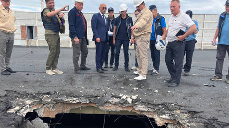 The IAEA team observes the damage caused by shelling on the roof of the special building at the ZNPP that houses, among other items, the fresh nuclear fuel and the solid radioactive waste storage facility.