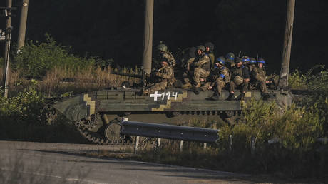 Ukrainian army's fighters sit on the top of an armed vehicle in Kharkov region. © AFP / Juan Barreto