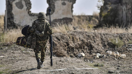 FILE PHOTO: An Armenian soldier carries a machine gun during the fighting in Nagorno-Karabakh.