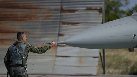 FILE PHOTO. The pilot of a Greek F-16 jet checks the aircraft before the takeoff at Tanagra air force.