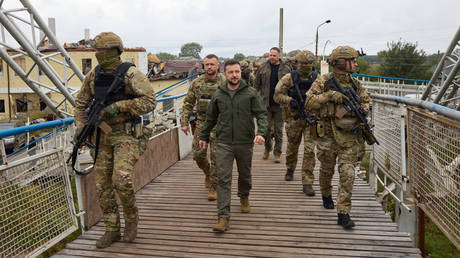 FILE PHOTO. Ukrainian President Vladimir Zelensky (C) walks with troops.