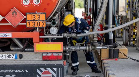 FILE PHOTO. An employee loads an oil transport truck in the Duna oil refinery, in Szazhalombatta, Hungary.
