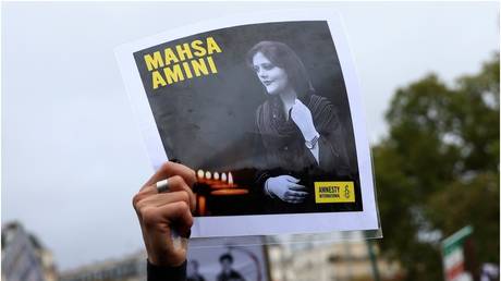 A protester holds a portrait of Mahsa Amini during a demonstration in Paris, October 2, 2022. © AP / Aurelien Morissard