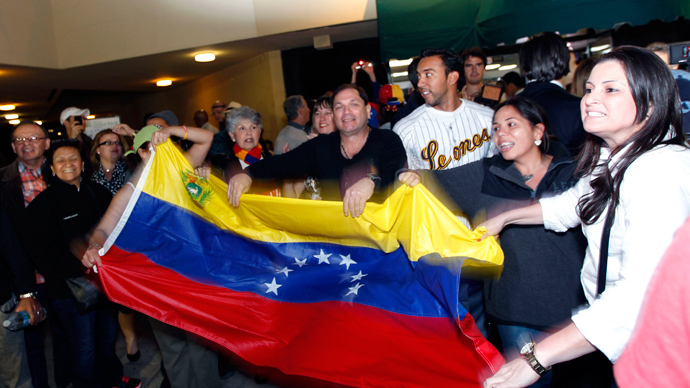 A crowd sings and waves the Venezuelan flag at a local restaurant following the death of Venezuelan President Hugo Chavez, in Doral, Florida, March 5, 2013 (Reuters / Robert Sullivan)