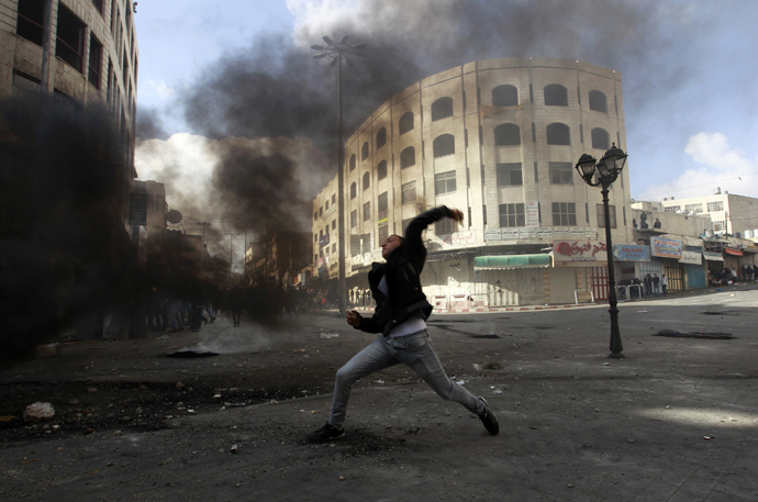 A Palestinian protester throws a stone during clashes with Israeli soldiers and border policemen in the West Bank city of Hebron February 24, 2013. (Reuters / Ammar Awad)