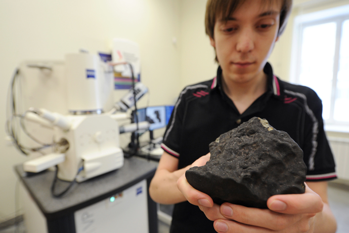 Grigory Yakovlev, engineer at the Research and Educational Center of Nanomaterials and Nanotechnologies of Ural Federal University, with fragment of the meteorite found during the expedition in the Chelyabinsk region. (RIA Novosti / Pavel Lysizin)
