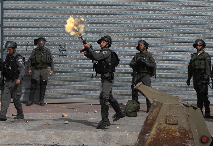 An Israeli border guard fires a tear gas cansiter during clashes with Palestinian youths outside Israel's Ofer prison near Ramallah on February 25, 2013. (AFP Photo / Abbas Momani)