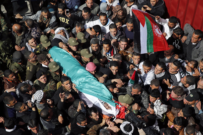 Palestinians carry the body of Arafat Jaradat as it arrives at his home before his funeral in the West Bank village of Se'eer near Hebron February 25, 2013. (Reuters / Darren Whiteside)