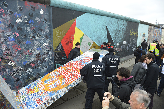 Police remove a piece of fake concrete used by protesters to fill out a whole during the removal of a section of the East Side Gallery, a 1,3 km long remainder of the Berlin Wall. (AFP Photo / Odd Andersen)
