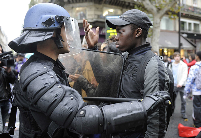 A French high school student faces anti-riot gendarmes during a student demonstration at the Place de la Republique in Paris. (AFP Photo / Gonzalo Fuentes)