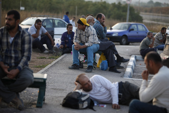 Palestinian labourers wait for work on the side of a road after crossing through Israel's Eyal checkpoint from the West Bank town of Qalqilya (Reuters/Nir Elias)