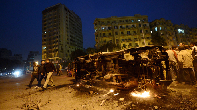 Egyptian look at a police vehicle that has been burnt by angry protesters following clashes with plainclothes policemen in Cairoâs on Tahrir square on March 3, 2013 (AFP Photo / Khaled Desouki)