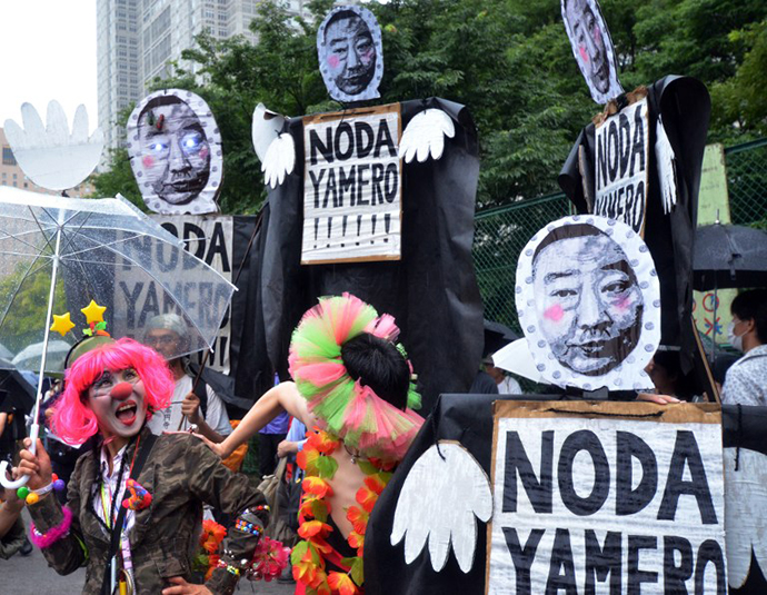 Anti nuclear activists hold placards during a demonstration on a street in Tokyo on July 1, 2012. (AFP Photo / Yoshikazu Tsuno)