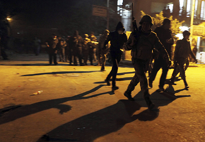 An army soldier (front) and protesters, who oppose Egyptian President Mohamed Mursi, flee from teargas fired by riot police during clashes in front of Security Directorate of Port Said after protesters started to set fire to it in Port Said city, 170 km (106 miles) northeast of Cairo March 5, 2013. (Reuters / Amr Dalsh)