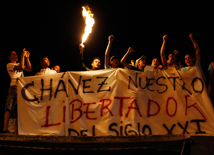 Supporters of Venezuela's President Hugo Chavez react to the announcement of his death outside the hospital where he was being treated, in Caracas, March 5, 2013. The banner reads, "Chavez, our liberator in the 21st Century." (Reuters / Carlos Garcia Rawlins)